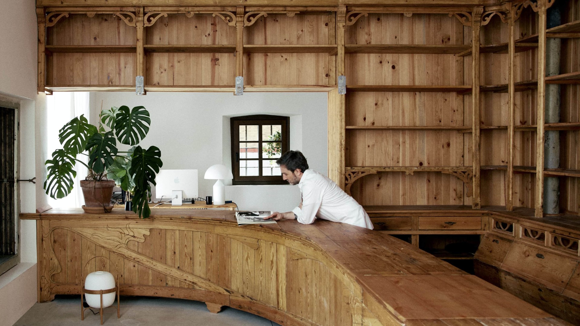 Hombre trabajando en oficina con mobiliario de madera vintage