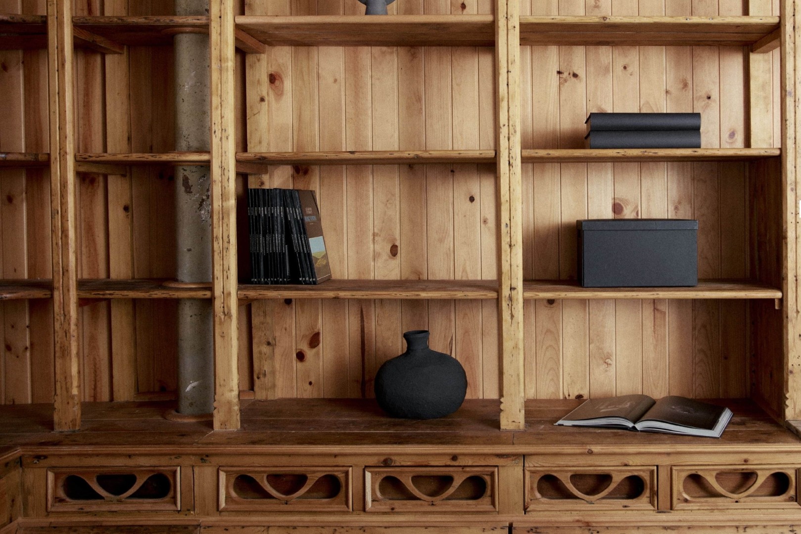 Estantería de madera rústica con libros y decoración minimalista