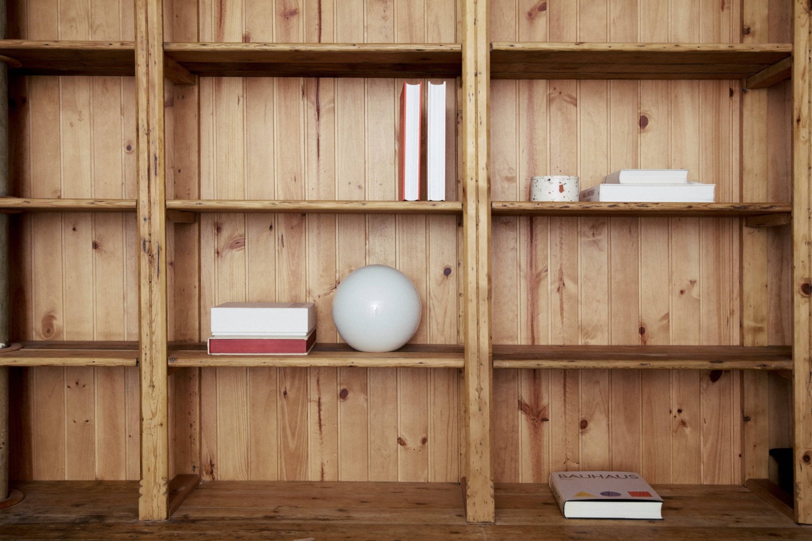 Estante de madera con libros y objetos decorativos minimalistas